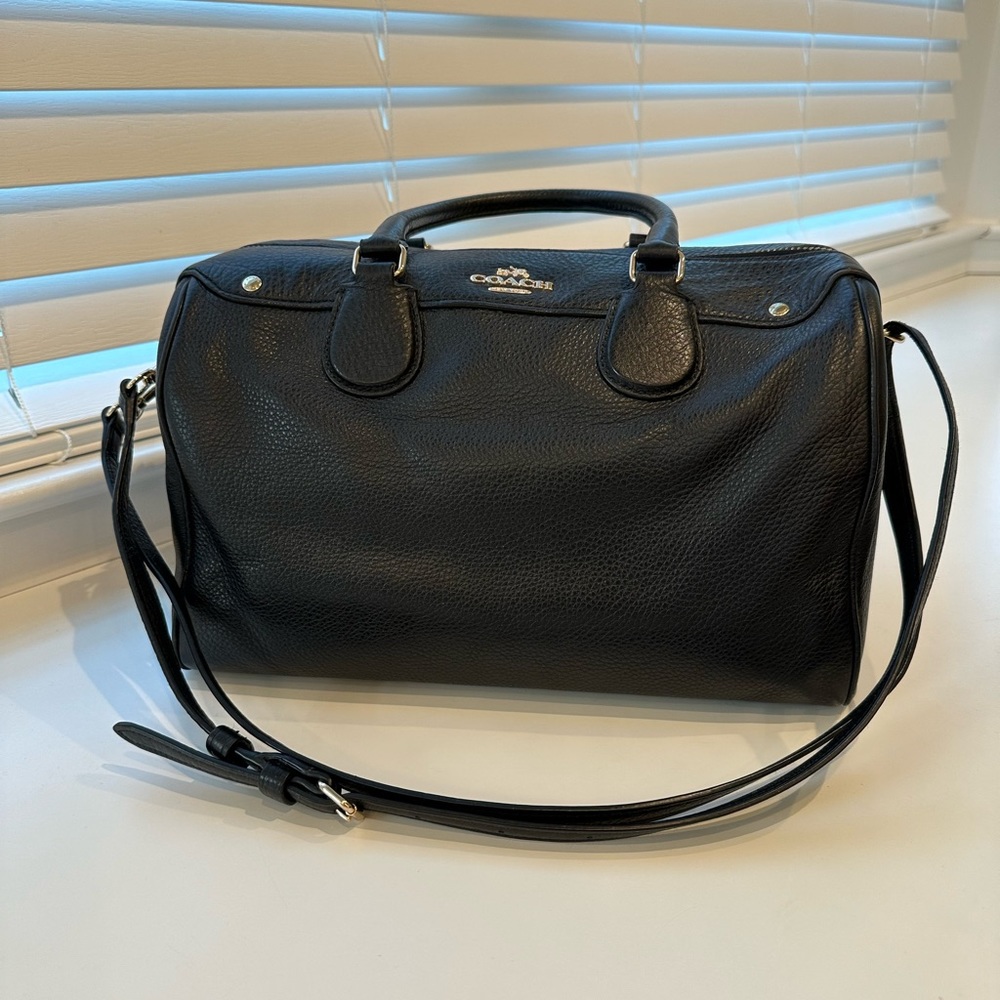 Black Coach bag with top handle and adjustable shoulder strap.